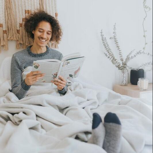 Man reading in bed and smiling
